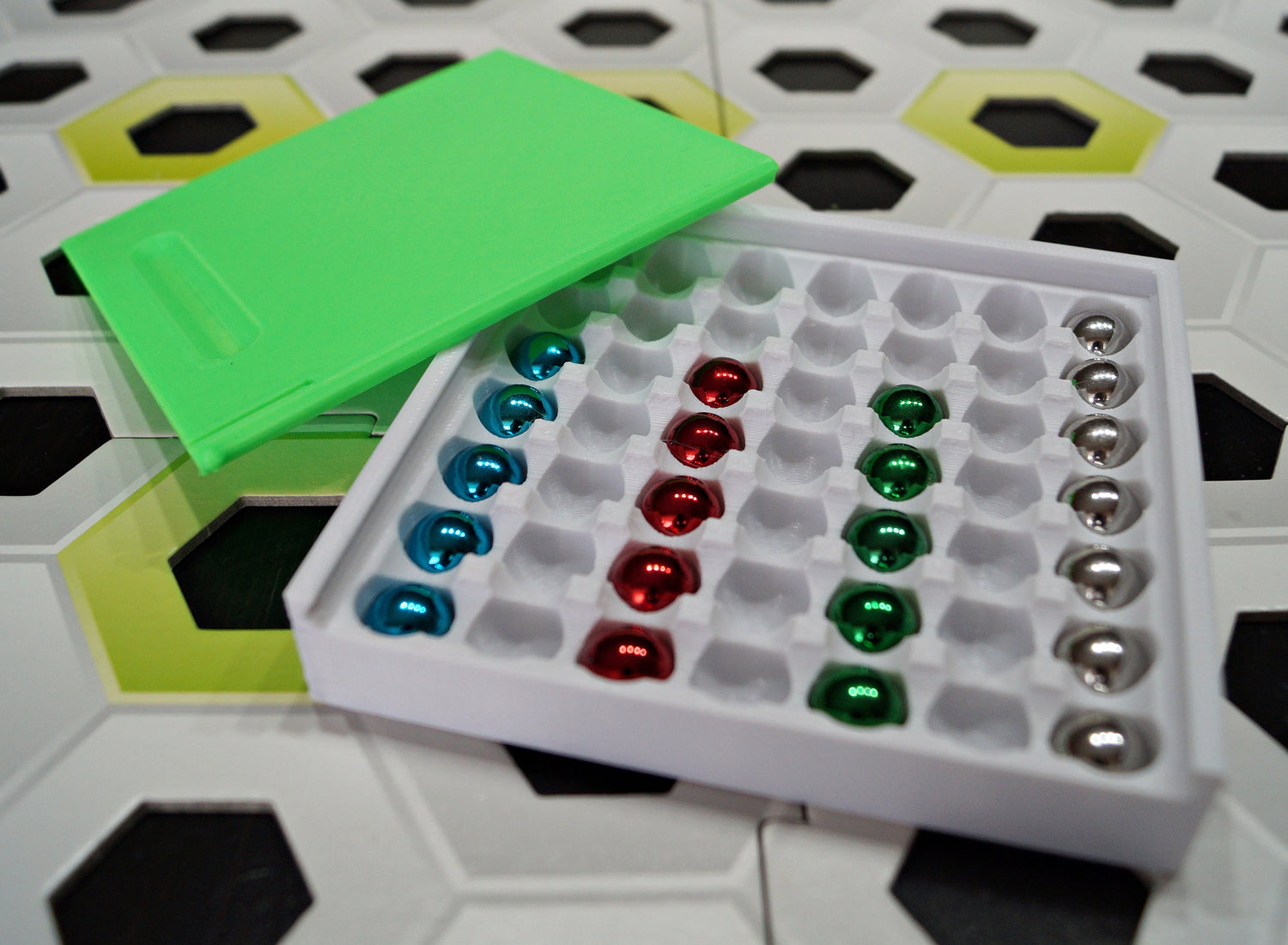3D-printed storage box with colorful Gravitrax compatible marbles on hexagonal board
