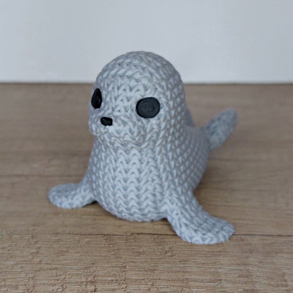 Seehund im Strick-Look aus hochwertigem 3D-Druck in Hellgrau, ca. 9 × 7 × 6 cm, als maritime Dekofigur für Wohnzimmer, Badezimmer oder Büro.