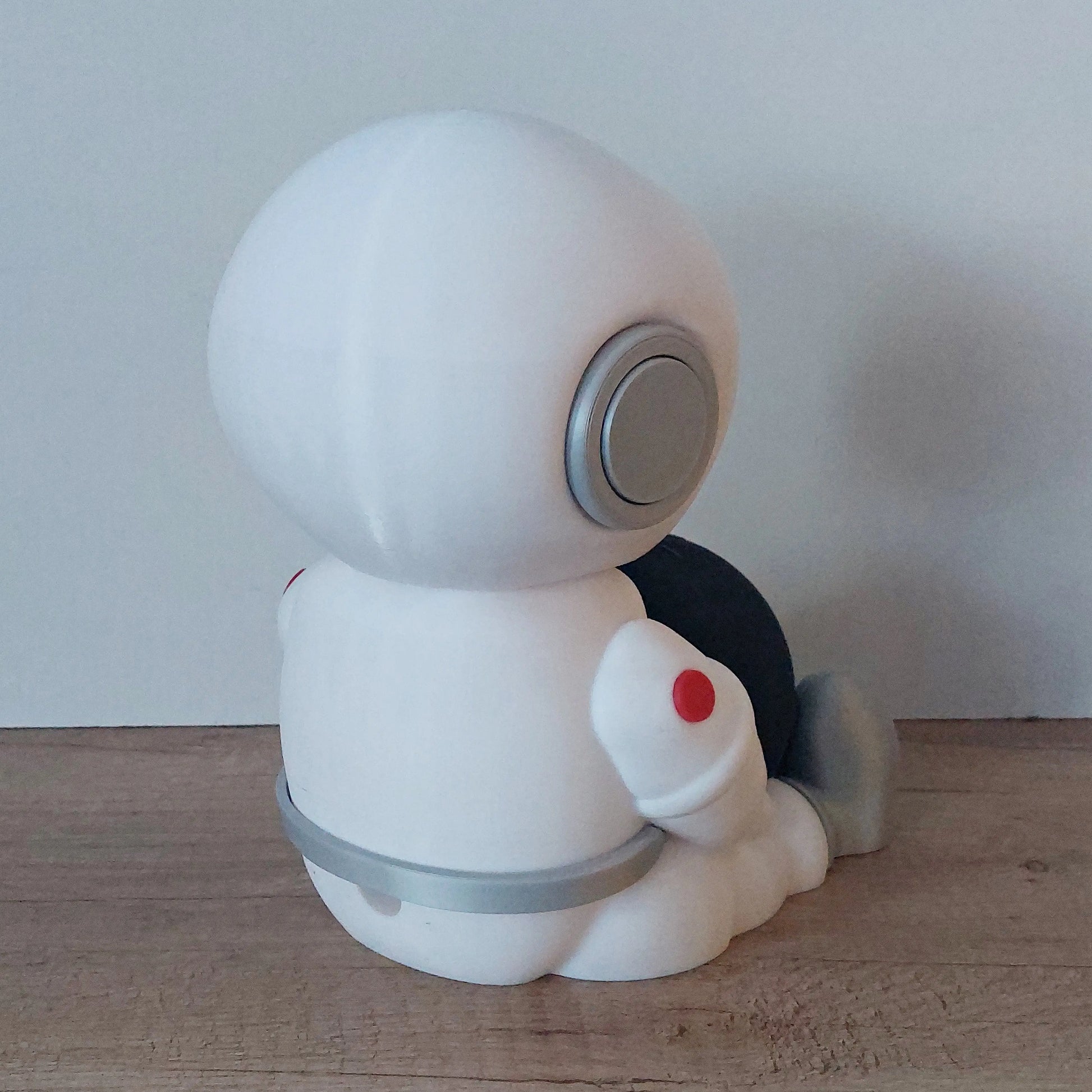 3D printed white robot figure with grey accents sitting on a wooden surface, megahobby3dcreations