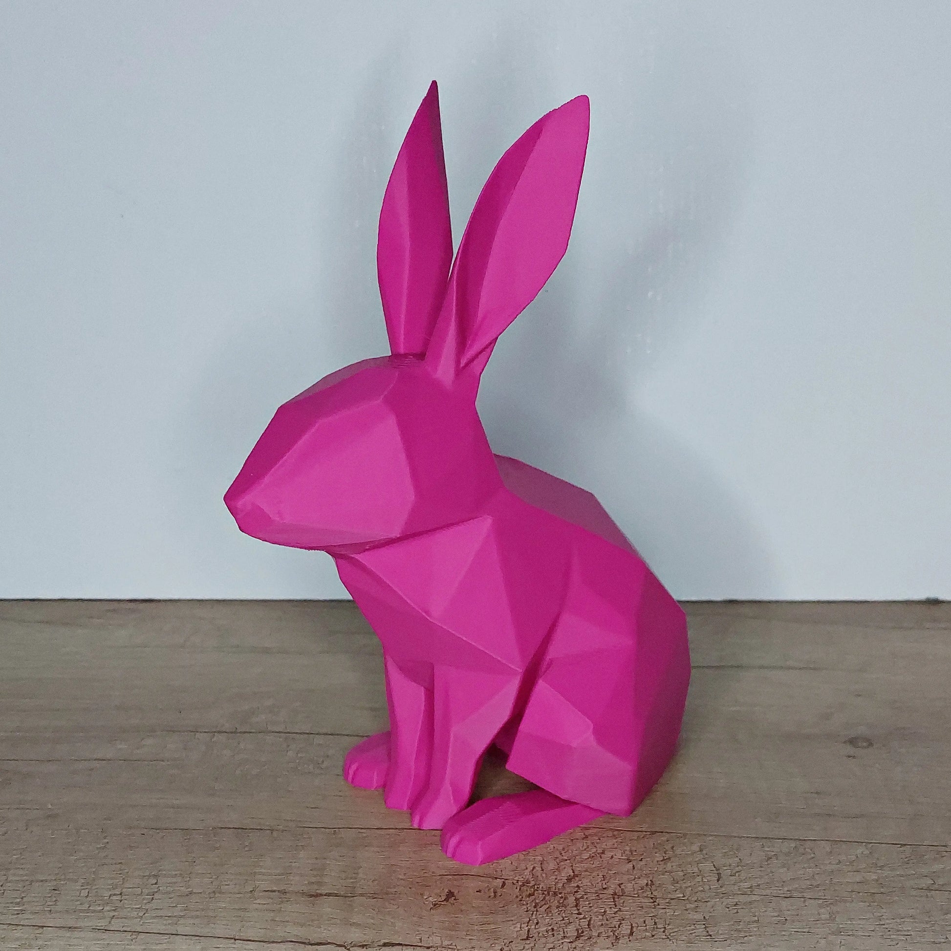 Pink geometric 3D printed rabbit figurine on wood surface from megahobby3dcreations