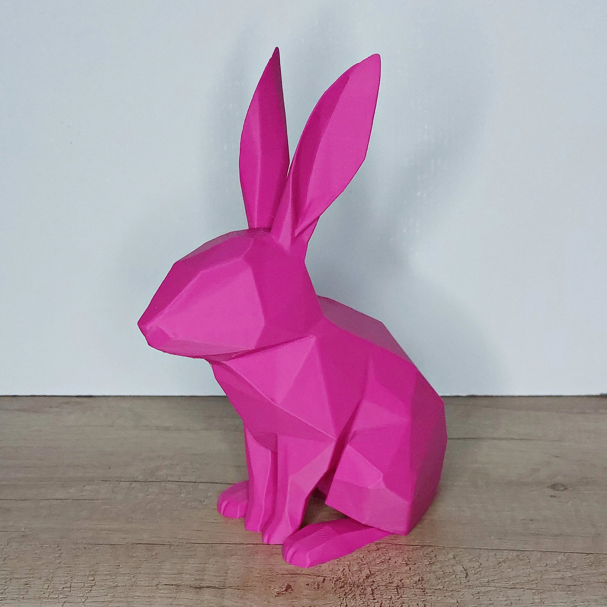Pink 3D printed geometric bunny figurine on a wooden surface from megahobby3dcreations