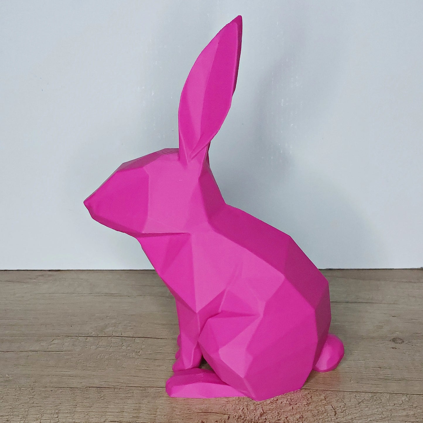 Pink geometric 3D-printed rabbit figurine on wooden surface, megahobby 3D creations