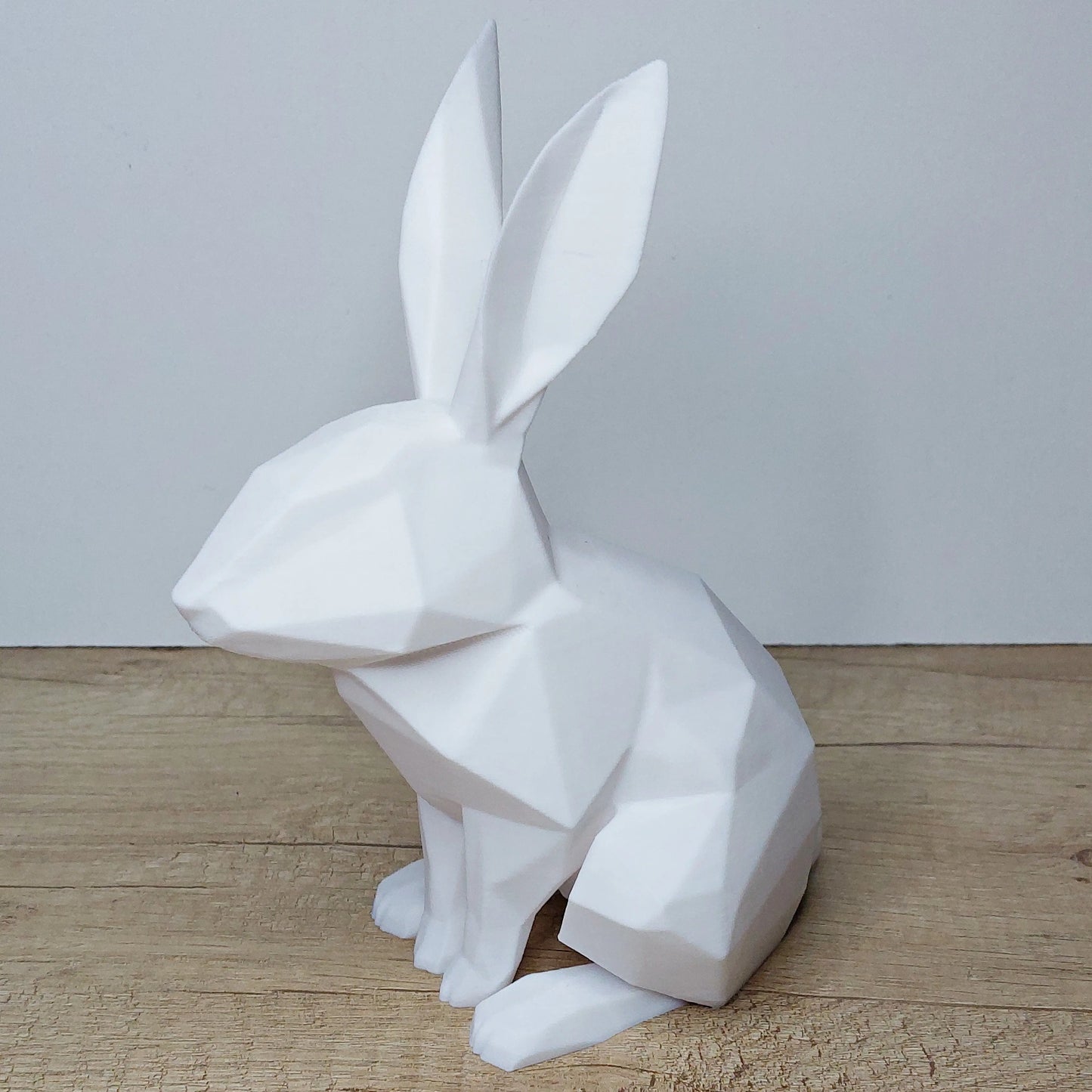 White geometric 3D printed rabbit figurine on wooden surface by megahobby3dcreations
