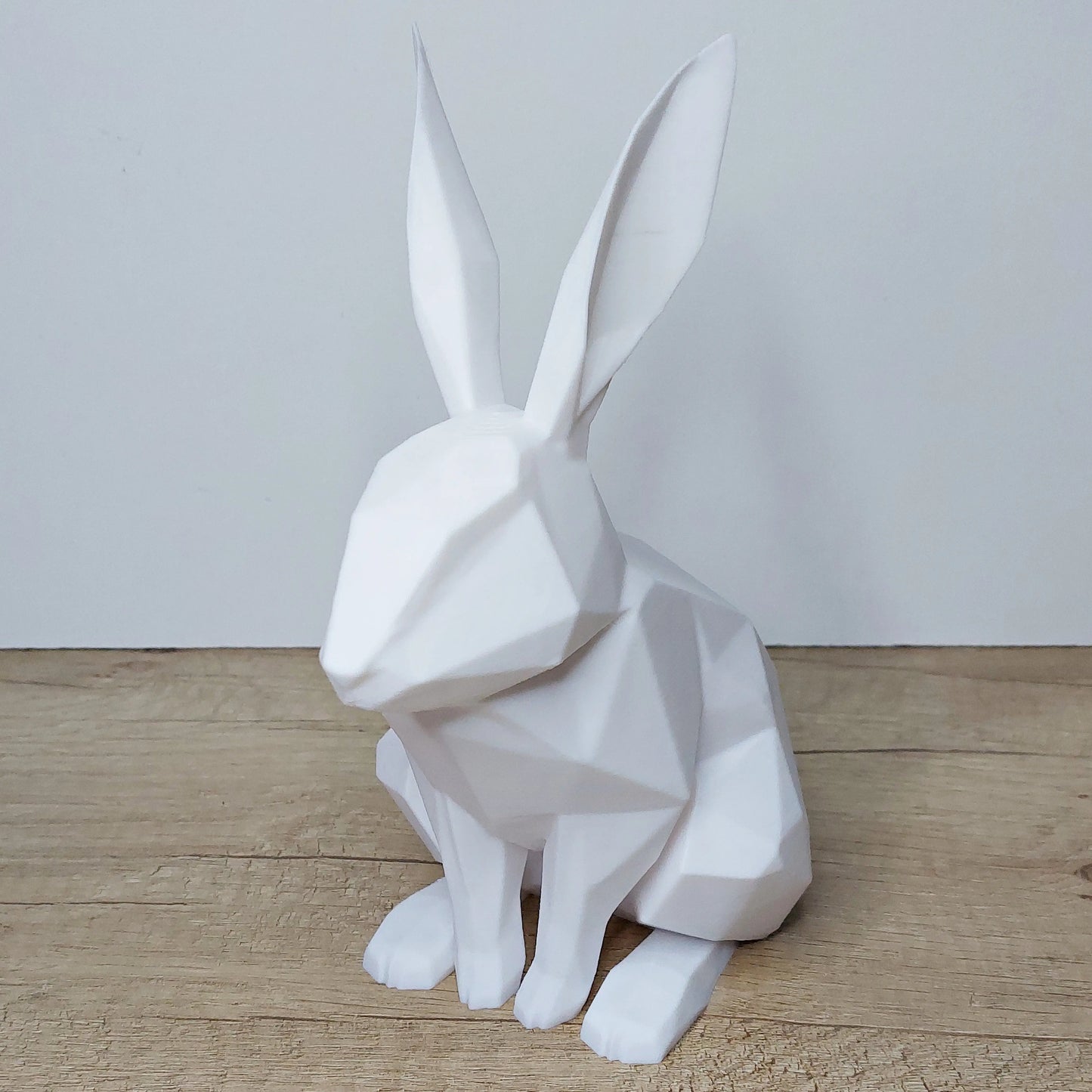 White geometric 3D printed rabbit figurine on wooden surface by megahobby3dcreations