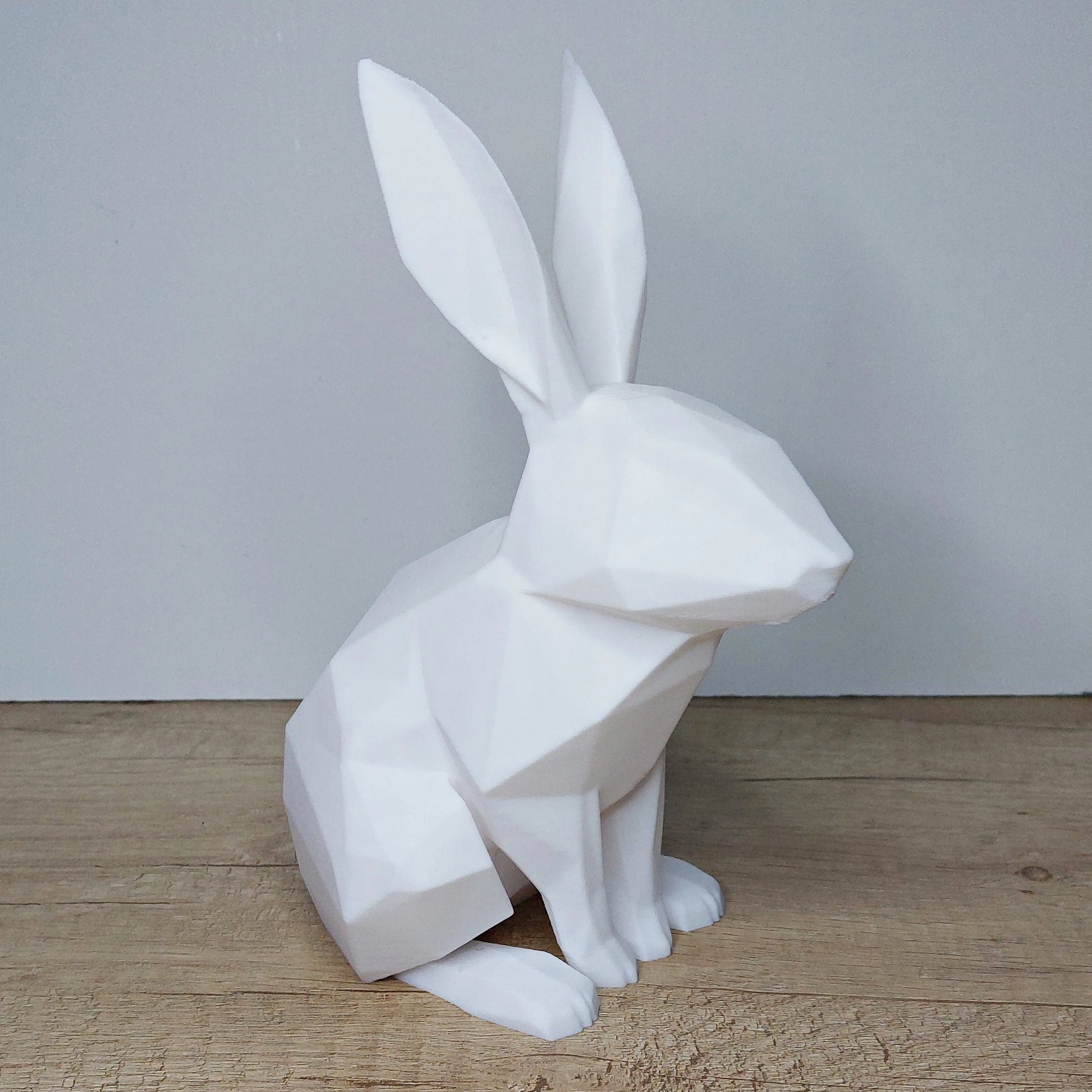 White geometric 3D printed rabbit figurine by megahobby3dcreations on wooden surface