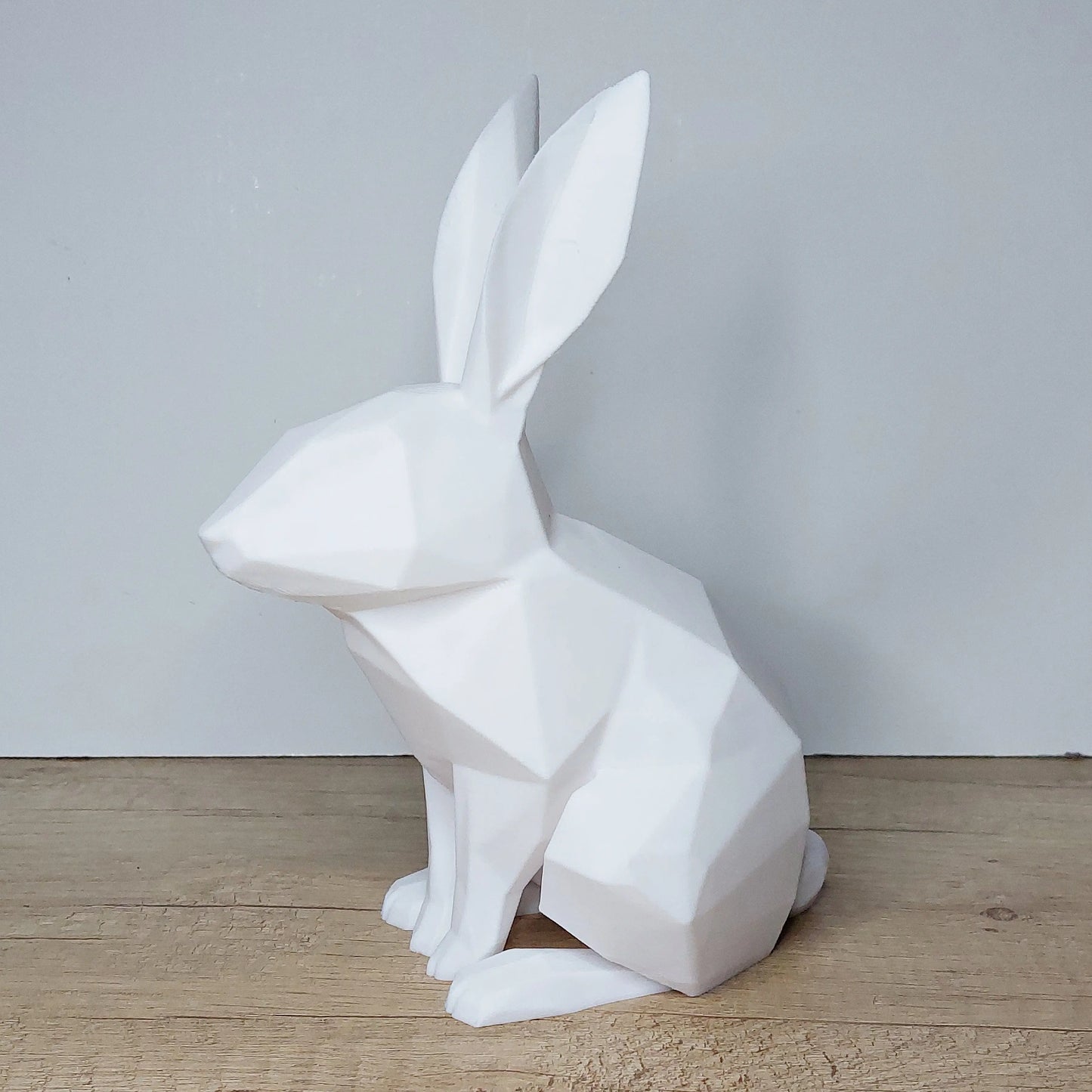 White geometric 3D printed rabbit figurine by megahobby3dcreations on wood surface