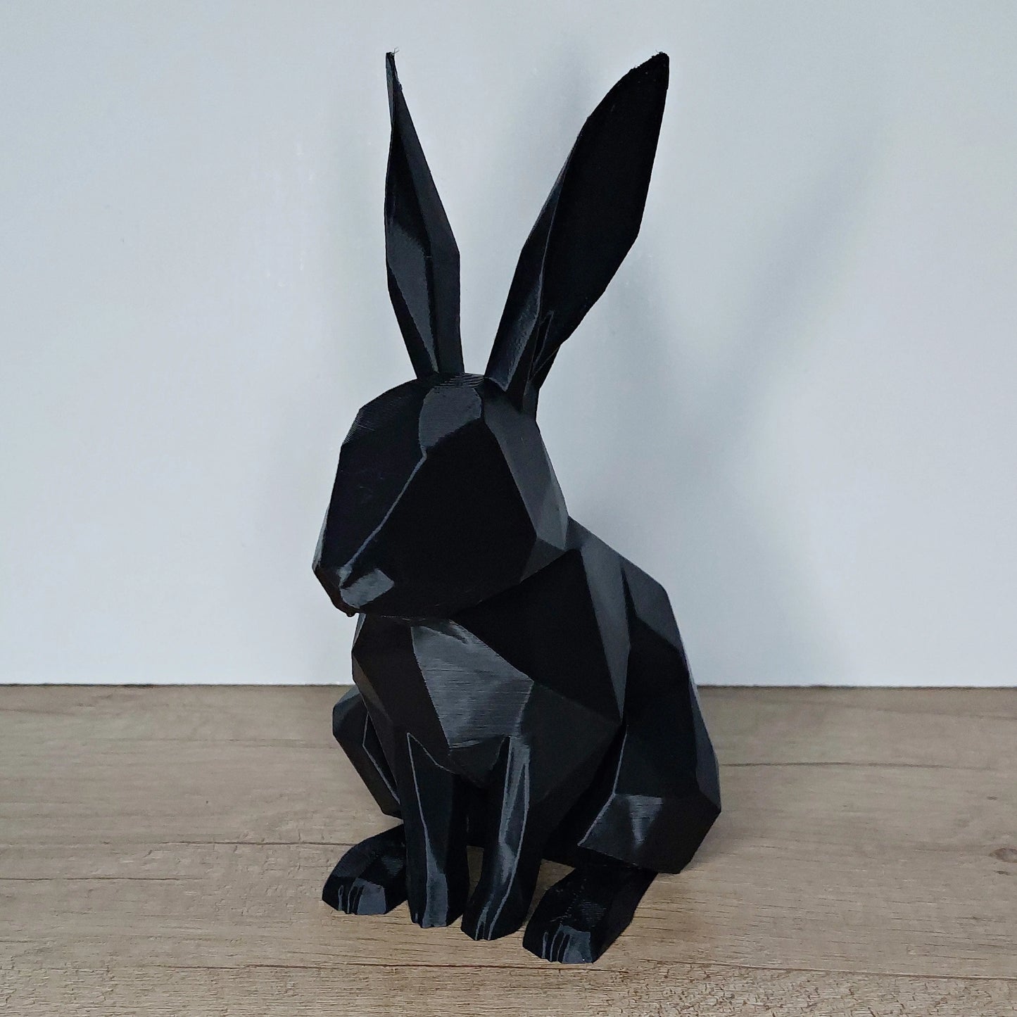 Black geometric 3D printed rabbit figurine on wood surface from megahobby3dcreations