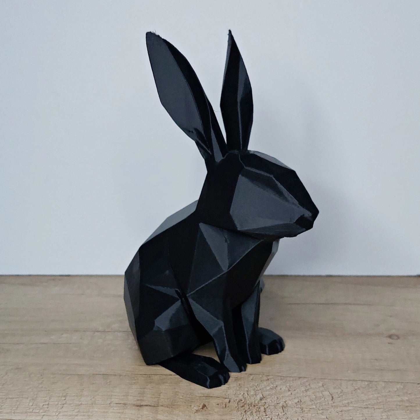 Black geometric 3D printed rabbit figure on wood surface, megahobby3dcreations decor