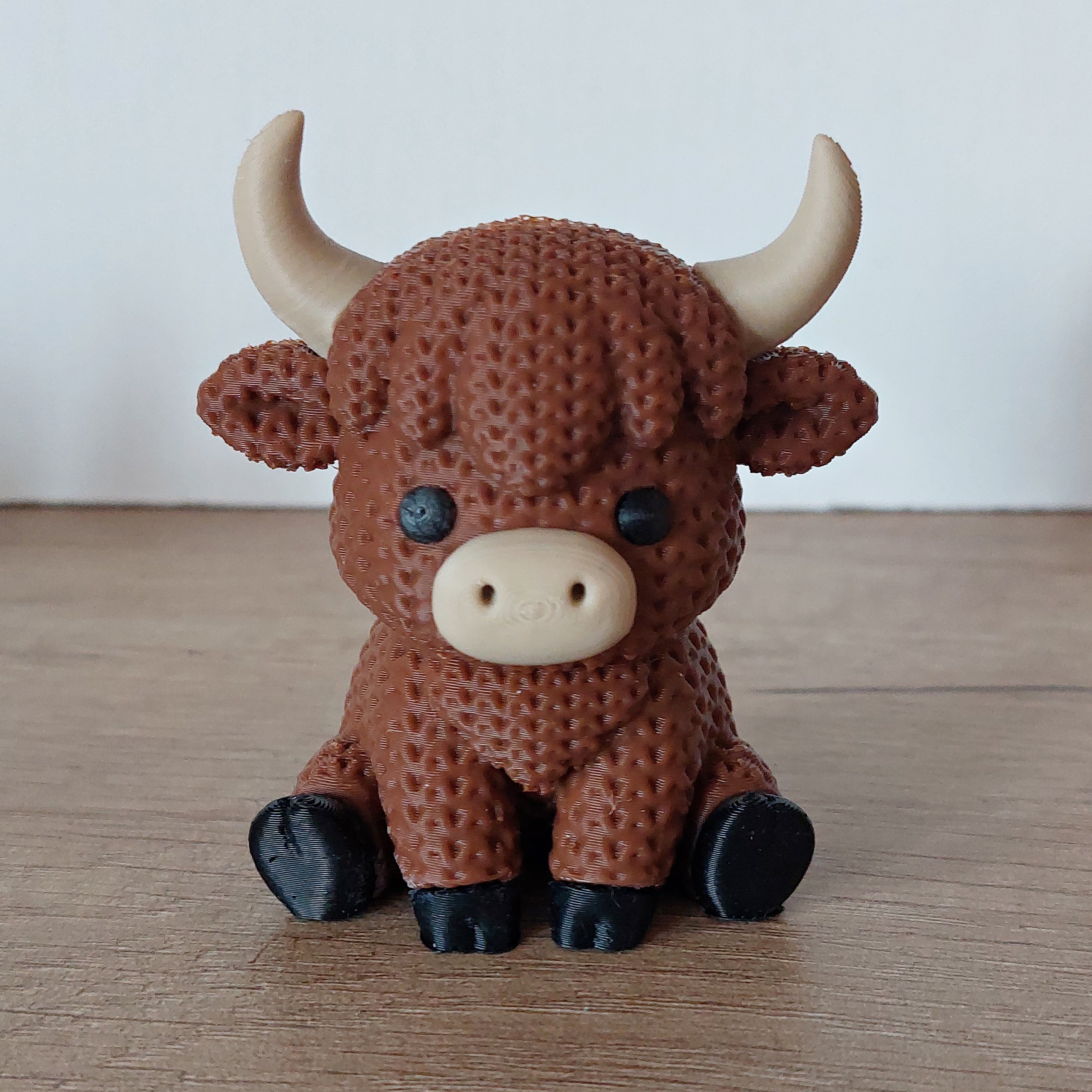 Schottische Hochland-Kuh im Strick-Look aus hochwertigem 3D-Druck in Dunkelbraun, ca. 7,5 × 5 cm, als dekorative Tierfigur für Wohnzimmer oder Büro.