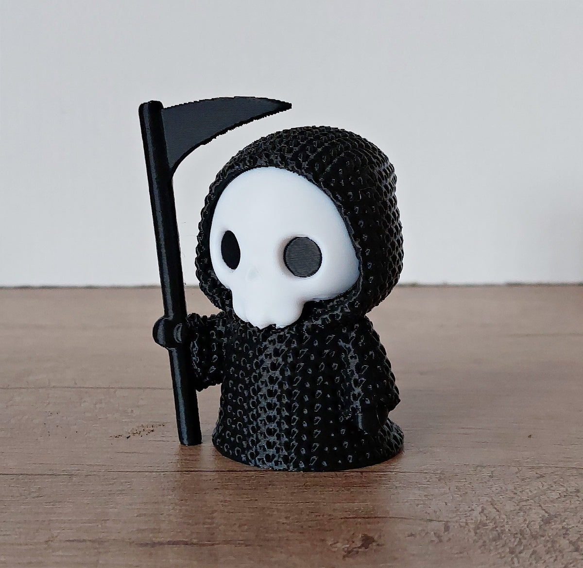 Kleine schwarze Halloween-Figur mit weißem Gesicht
